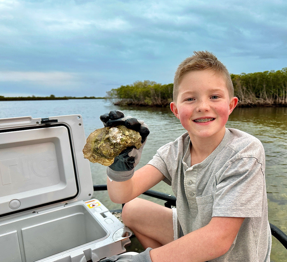 Child holding Oyster he harvested in Crystal River Florida